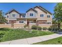 Charming townhouse with a well-maintained lawn, stone accents, and inviting curb appeal at 12856 Jasmine St # E, Thornton, CO 80602