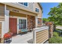 Cozy front porch with seating and decorative flower pot, enhances curb appeal at 12856 Jasmine St # E, Thornton, CO 80602