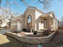Attractive stucco home featuring brick accents, a bench, and a well-kept stone garden bed at 6700 W Dorado Dr # 42, Littleton, CO 80123