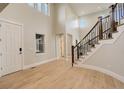 Bright foyer with light hardwood floors, staircase with wrought iron railing, and high ceilings at 5334 Sedona Dr, Parker, CO 80134
