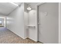 Clean hallway with light gray walls, carpet flooring, and apartment doors at 660 S Alton Way # 10D, Denver, CO 80247