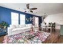 Inviting living area with dark blue accent wall, comfortable seating, and hardwood flooring at 3412 Valentia St, Denver, CO 80238