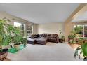 Comfortable living room with a leather sectional sofa, large windows, and plants at 106 Cherry St, Castle Rock, CO 80104