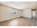 Inviting living room featuring new floors, a large window, and neutral paint, creating a cozy atmosphere at 3771 S Federal Blvd, Englewood, CO 80110