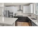 A stunning kitchen has white cabinets, stainless steel appliances, and quartz countertops at 12374 Farmview St, Thornton, CO 80241