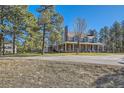Spacious home with a welcoming porch, nestled among mature trees and a serene landscape at 38666 County Road 21, Elizabeth, CO 80107