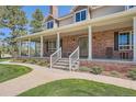 Inviting brick front porch with white columns and railing, offering ample space and a welcoming entrance at 38666 County Road 21, Elizabeth, CO 80107