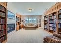 Cozy living room featuring custom built-in bookshelves, a stone fireplace, and ample natural light at 38666 County Road 21, Elizabeth, CO 80107