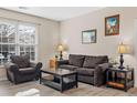 Cozy living room features neutral walls, wood-look floors, and great natural light from a bright window at 4084 S Crystal Cir # 104, Aurora, CO 80014