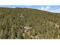 Aerial view of a home nestled amongst lush greenery and mature trees at 20410 Brookmont Rd, Morrison, CO 80465