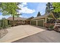 Large driveway with three-car garage and stone accents at 20410 Brookmont Rd, Morrison, CO 80465