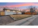 Classic single-story house with a modern front door, attached garage, and a partially brown lawn at 214 Iowa Dr, Golden, CO 80403