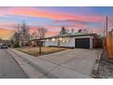 Inviting single-Gathering home featuring a driveway leading to a garage, a front lawn, and a tidy landscape at 214 Iowa Dr, Golden, CO 80403