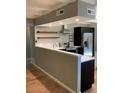 Modern kitchen featuring a bar top, stainless steel appliances, and wood shelves at 1040 Stuart St, Denver, CO 80204