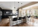 Stylish kitchen with black cabinets, granite countertops, stainless steel appliances and a seamless transition to the dining area at 3472 Harvard Pl, Broomfield, CO 80023