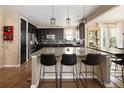 Spacious kitchen features sleek black cabinetry, a large center island, and stainless steel appliances, perfect for culinary enthusiasts at 3472 Harvard Pl, Broomfield, CO 80023