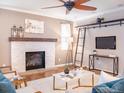 Cozy living room featuring a stone fireplace, ceiling fan, and stylish decor at 3472 Harvard Pl, Broomfield, CO 80023