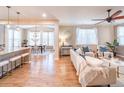 Bright and airy living room with hardwood floors, neutral decor, and seamless access to the dining area at 3472 Harvard Pl, Broomfield, CO 80023