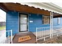 Welcoming blue home featuring covered porch and a 'Hello' doormat at 1235 S Zenobia St, Denver, CO 80219