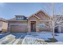 Charming house with a two-car garage and snow-covered yard at 4967 S Ukraine St, Aurora, CO 80015