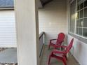 Relaxing front porch with a pair of red chairs, a small table, and view of the home's exterior at 2227 Chestnut Cir, Erie, CO 80516