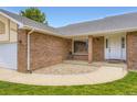 Inviting front entry of a brick home, featuring a cozy sitting area at 3743 W 103Rd Dr, Westminster, CO 80031