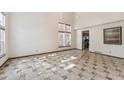 Bright living room boasting a high ceiling, decorative light fixtures and tile flooring at 13486 Clayton St, Thornton, CO 80241