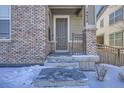 Gray front door with a small porch and steps leading to the home's entrance at 16630 E Virginia Ave, Aurora, CO 80017