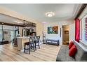 Open-concept living room with hardwood floors, a modern sofa, and seamless kitchen access at 1701 Kingston St, Aurora, CO 80010