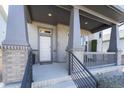 Inviting front porch with brick accents, offering a cozy outdoor space with stylish railings and ample room at 21574 E 59Th Dr, Aurora, CO 80019