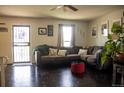 Cozy living room featuring dark hardwood floors, a comfortable sectional sofa, and ample natural light at 19930 E Cornell Ave, Aurora, CO 80013