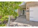 Charming front entrance with brick facade and decorative house number; mature trees enhance curb appeal at 2950 Wyecliff Ln, Highlands Ranch, CO 80126