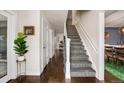 Hallway with hardwood floors leading to the staircase and other rooms, showcasing the home's interior layout at 6869 S Niagara Ct, Centennial, CO 80112
