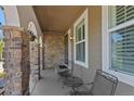 Charming front porch featuring stone columns and comfortable seating, perfect for relaxing and enjoying the outdoors at 12015 Blackwell Way, Parker, CO 80138