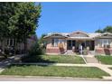 Street view showing two-story home with brick exterior, landscaping, and sidewalk at 1415 Raleigh St, Denver, CO 80204