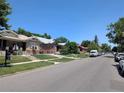 Residential street view of neighborhood with single-Gathering homes and mature trees at 1415 Raleigh St, Denver, CO 80204