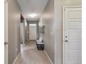 Bright hallway with wood-look flooring, modern lighting, and neutral paint at 806 Peony Ct, Brighton, CO 80601