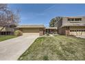 Charming brick home showcasing a well-manicured lawn and attached two-car garage at 32 Eagle Dr, Littleton, CO 80123