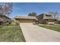 Charming brick home showcasing a well-manicured lawn and attached two-car garage at 32 Eagle Dr, Littleton, CO 80123