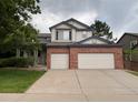 Two-story home featuring a brick facade and a spacious three-car garage at 10027 Sylvestor Rd, Highlands Ranch, CO 80129