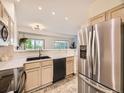 Contemporary kitchen features stainless steel appliances and a breakfast bar that opens to the living room at 12265 E 2Nd Dr, Aurora, CO 80011
