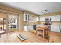 Bright kitchen with stainless steel appliances, white cabinets, and a view to the backyard patio at 4621 S Perry Way, Denver, CO 80236