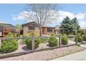 Brick home featuring a fenced yard with lush greenery, mature trees, and a stone walkway at 3580 Locust St, Denver, CO 80207