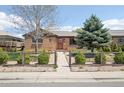 Beautiful brick home with landscaped front yard, mature trees, and charming fenced garden at 3580 Locust St, Denver, CO 80207