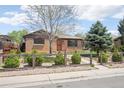 A brick home with mature trees and landscaping is fenced in at 3580 Locust St, Denver, CO 80207