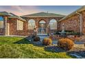 Charming brick home with manicured lawn, fountain and beautiful front entry gate at 3810 Urban St, Wheat Ridge, CO 80033