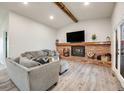 Comfortable living room featuring a cozy brick fireplace, mantel, and neutral furnishings at 14867 E Pacific Pl, Aurora, CO 80014