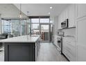 Modern kitchen featuring white cabinets, stainless steel appliances, and a large island with city views at 1700 Bassett St # 1301, Denver, CO 80202