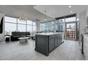 Open concept living area with modern kitchen island, sleek countertops, and large windows showcasing city views at 1700 Bassett St # 1301, Denver, CO 80202