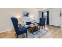 Cozy living room with blue seating and a stylish coffee table on a decorative rug at 7822 South Kittredge Circle, Englewood, CO 80112